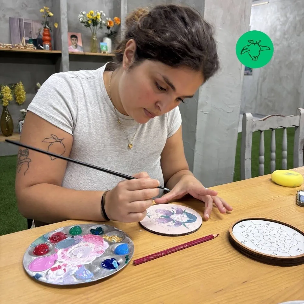 Taller Puzzle Trencadís en Barcelona con participante pintando su pieza de madera
