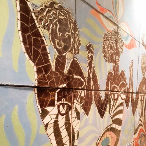 Detalle sugerente de formas naturales con la técnica del trencadís con cerámica blanca y de colores.