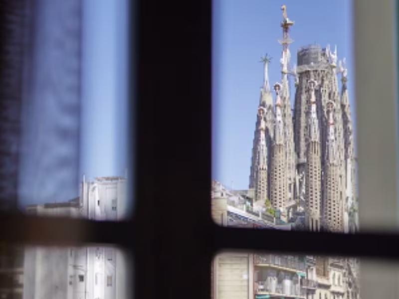 Medalla conmemorativa Gaudí 2026 Edición Hostemplo sostenida frente a la Sagrada Família de Barcelona.
