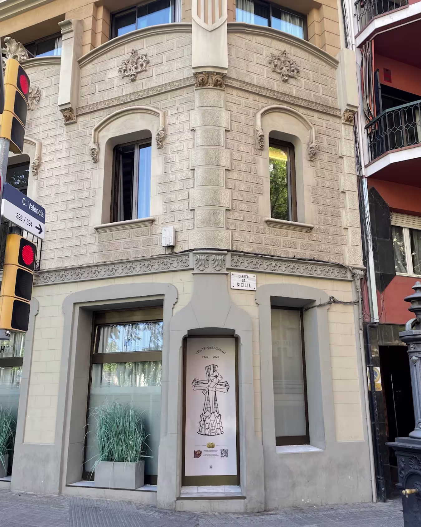 Fachada de Hostemplo con el cartel conmemorativo del Centenario Gaudí 2026 cerca de la Sagrada Família.