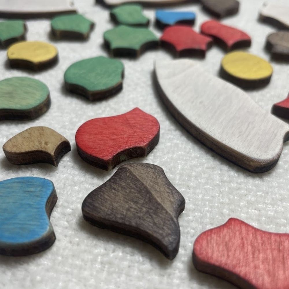 Piezas sueltas del Puzzle Trencadís pintadas en rojo, verde, azul y amarillo