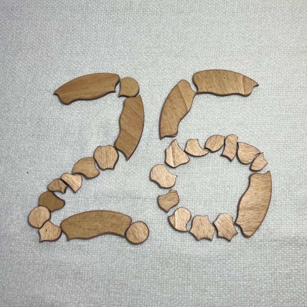 Piezas de madera del Puzzle Trencadís colocadas formando el número 26