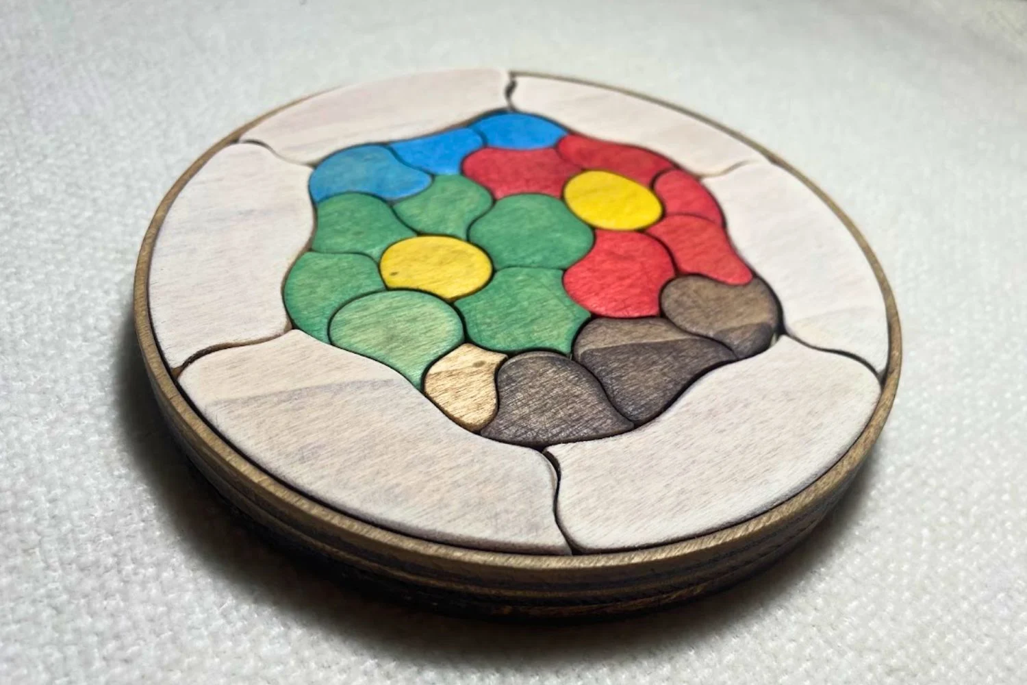 Puzzle Trencadís pintado de colores visto en perspectiva sobre una superficie clara
