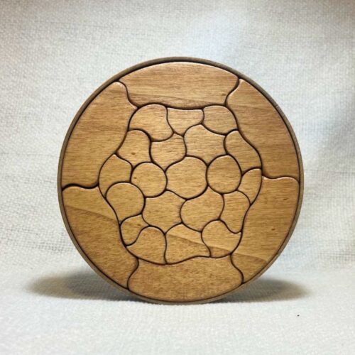 Puzzle Trencadís de madera de Petit Gaudí colocado en vertical sobre fondo claro