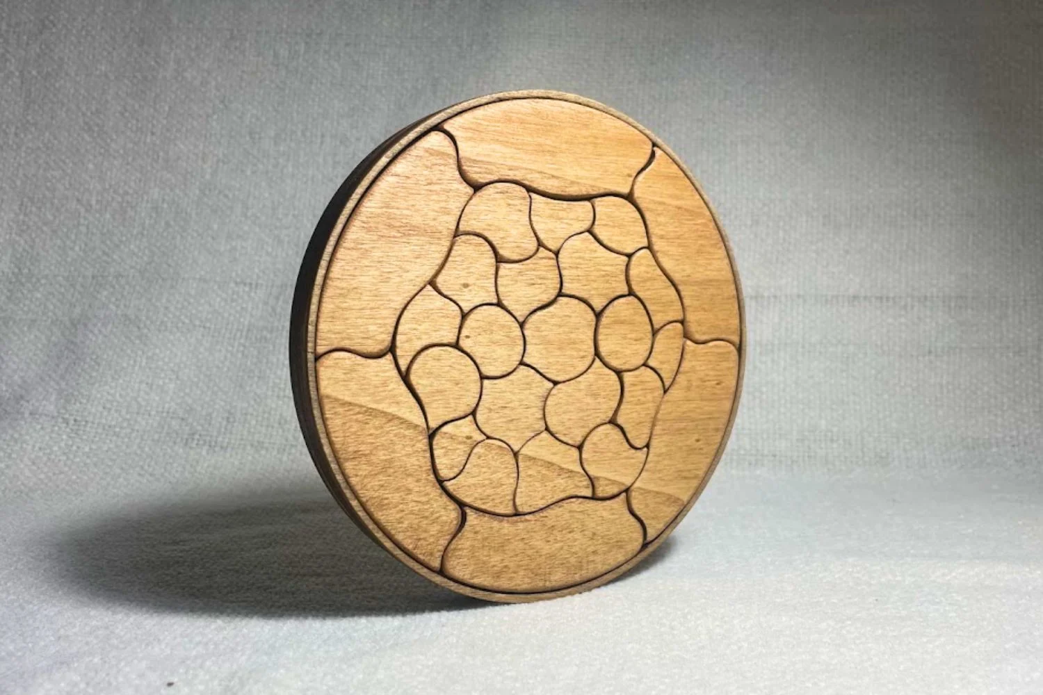 Puzzle Trencadís en madera natural apoyado verticalmente y visto en tres cuartos