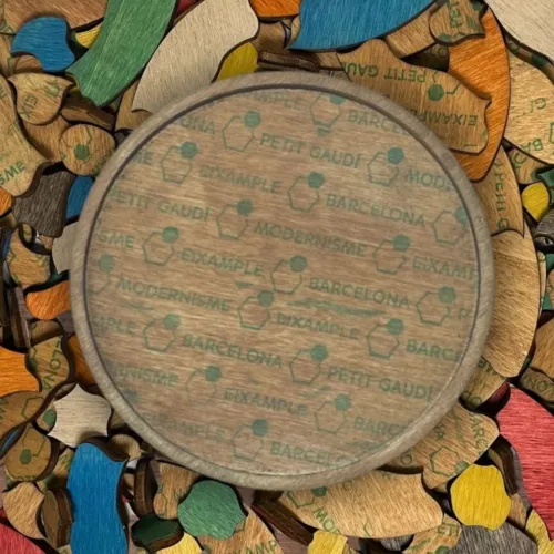Parte trasera del Puzzle Trencadís Multicolor apoyada sobre un fondo de piezas de colores