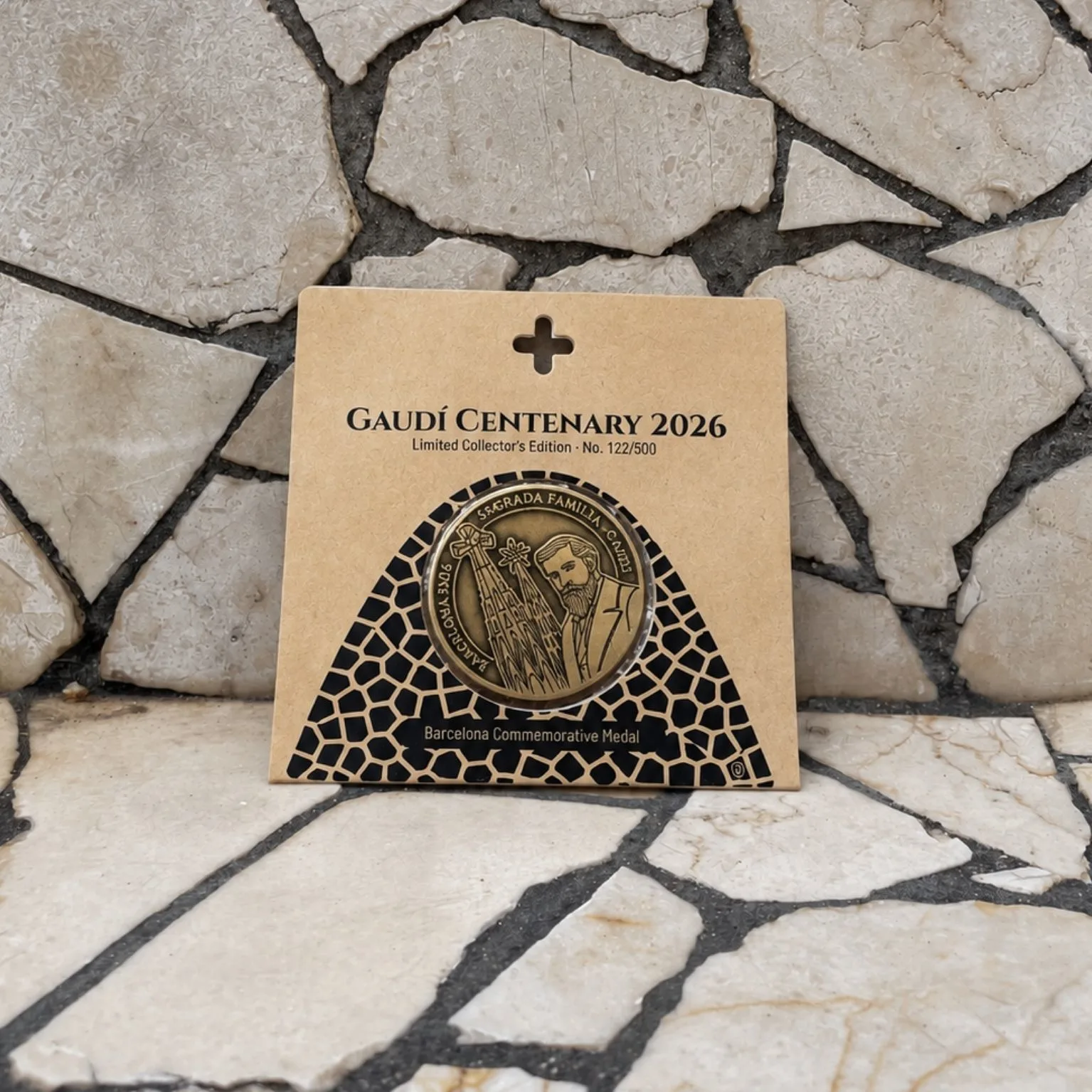 Medalla Gaudí 2026 sobre un banco de trencadís en Passeig de Gràcia, Barcelona